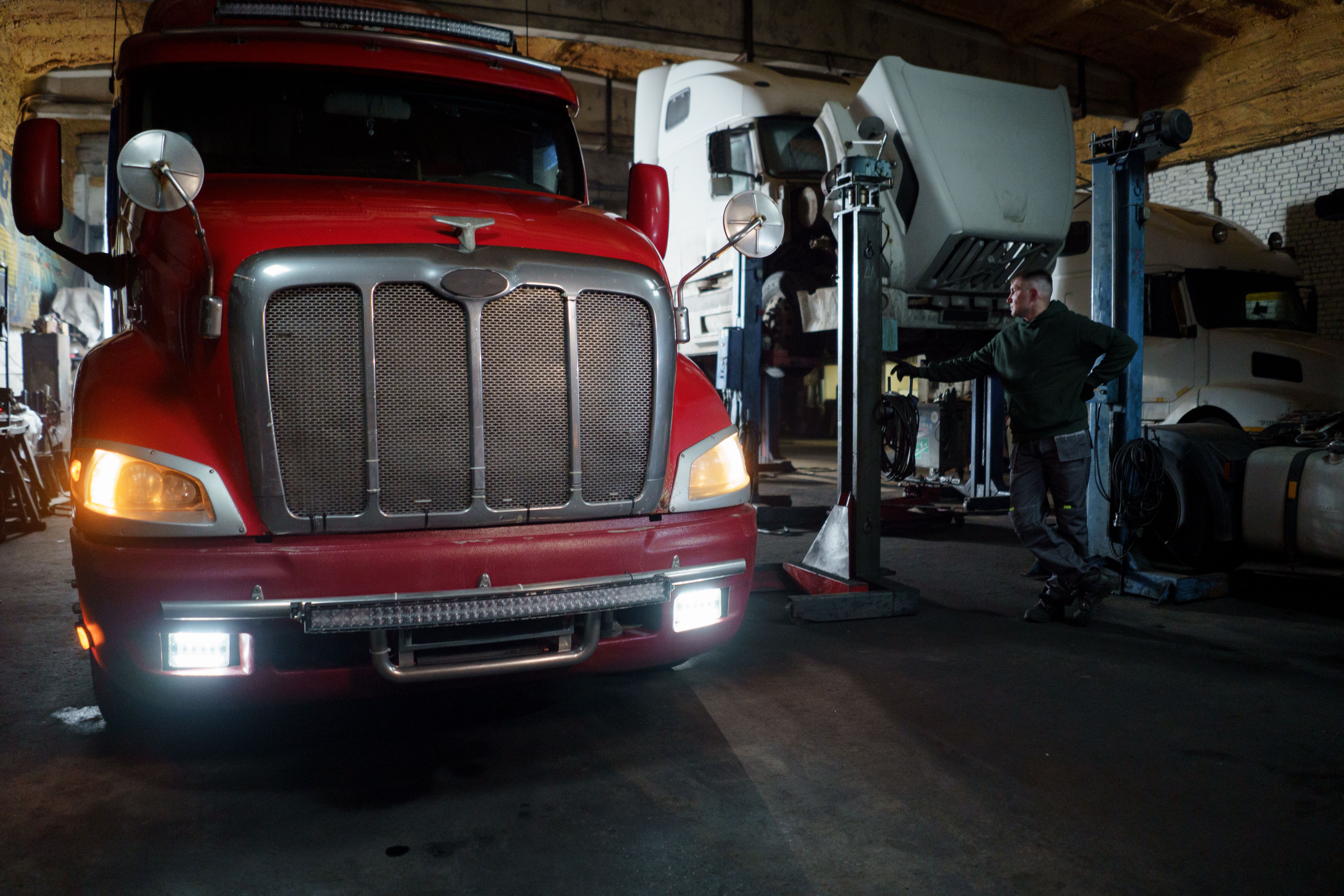 A trucking professional coordinating freight logistics operations, reviewing shipment details at a warehouse dock.